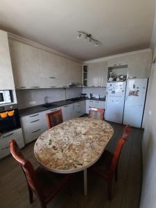 a kitchen with a table and chairs in a kitchen at Garni Guesthouse in Garni