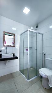 a bathroom with a glass shower and a toilet at Pousada Brisa e Mar in Praia do Frances