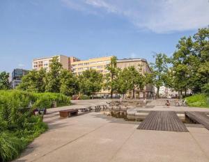 park z ławkami, stawem i budynkami w obiekcie :: Apartment City Center :: w Warszawie