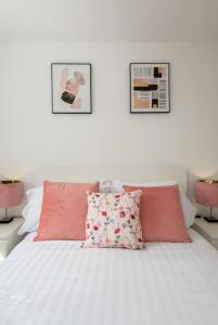 a bed with pink and white sheets and pillows at Bell Road in Durham