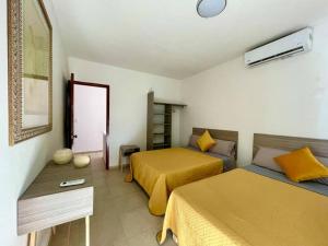 um quarto de hotel com duas camas e uma mesa em Casa Mar y Amor em Cancún