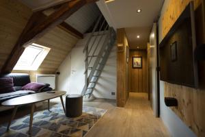a room with a couch and a table and a staircase at Hôtel Restaurant Les Alisiers in Lapoutroie