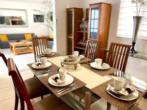 mesa de comedor con sillas y mesa de cristal en Casa Mar y Amor en Cancún