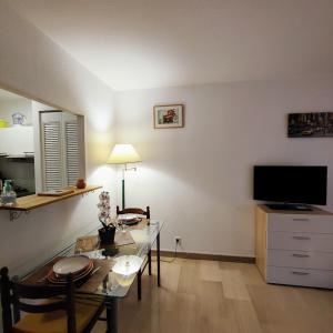 un soggiorno con un tavolo e una televisione di Fréjus plage a Fréjus