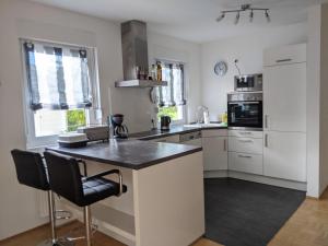 a kitchen with white cabinets and a black counter top at Ferienhaus Lindelburg in Schwarzenbruck