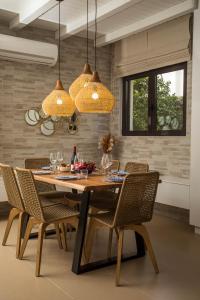 a dining room with a wooden table and chairs at Villa Laila in Ialyssos