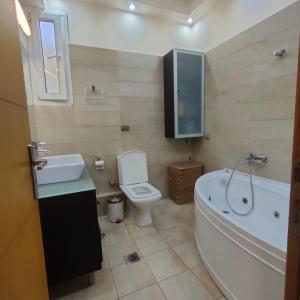 a bathroom with a tub and a toilet and a sink at MUSEUM apartment in Volos