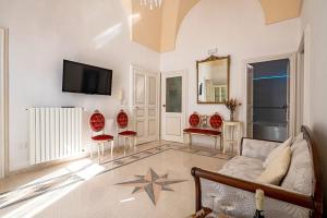 a living room with a couch and chairs and a tv at Palazzo Giannotte Suite & Spa in Ostuni