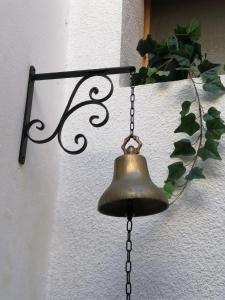 une cloche suspendue sur un mur avec une plante dans l'établissement Riad Siham, à El Jadida