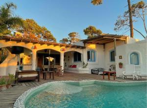 a house with a swimming pool in front of a house at El Delfin in Punta del Este