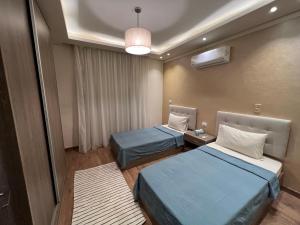 una habitación de hospital con 2 camas y una lámpara en Families Only - Rehab 2 - Two Bedrooms Flat for you en Burg el-Ḥudûd