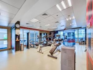 a gym with a large room with cardio equipment at Bright Sunny Dubai Apartment- Private Terrace Garden- Canal Views- Pool & Gym in Dubai