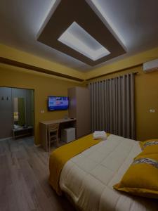 1 dormitorio con 1 cama grande y TV en Hotel Xhelili, en Cërrik