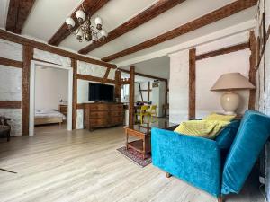 a living room with a blue couch and a television at nouvel appartement, Le Colombage Heureux in Sélestat