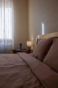 a bedroom with a bed and a window with a lamp at Olimpija Hotel & SPA in Daugavpils