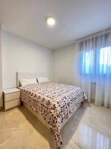 a bedroom with a bed with a floral bedspread at Fabuloso apartamento completo centro ciudad in Móstoles