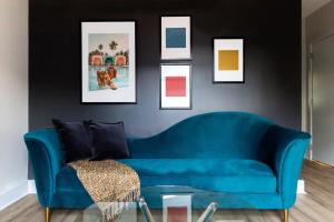 a blue couch in a living room with pictures on the wall at Kasa Edison House South End Dilworth Charlotte in Charlotte