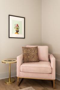 a pink chair and a table in a room at Kasa Edison House South End Dilworth Charlotte in Charlotte