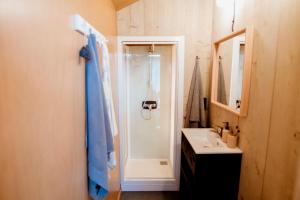 a bathroom with a shower and a sink at Safari Lodge, glamping aan zee! in Callantsoog