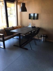 een woonkamer met een tafel en een bank bij Safari Lodge, glamping aan zee! in Callantsoog