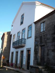 Casa blanca con balcón y edificio de ladrillo en Casa Pires Mateus, en Monsanto