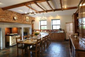 a large kitchen with a wooden table and chairs at Tywysog in Henllan