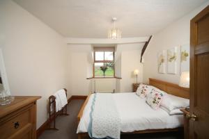 um pequeno quarto com uma cama e uma janela em Tywysog em Henllan