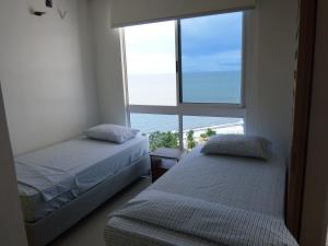 1 dormitorio con 2 camas y ventana grande en Apartamento Reserva Del Mar, en Santa Marta
