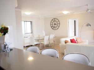 a living room with a couch and a table and chairs at Edge Apartments Cairns in Cairns