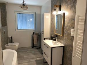 a bathroom with a sink and a toilet and a mirror at Beskidzki Zakątek Krynica-Zdrój in Krynica Zdrój