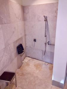 uma casa de banho com um chuveiro com um banco em Parador de Alcalá de Henares em Alcalá de Henares