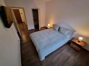 um quarto com uma cama branca e duas mesas de cabeceira em Avram Iancu Private Apartment em Brasov