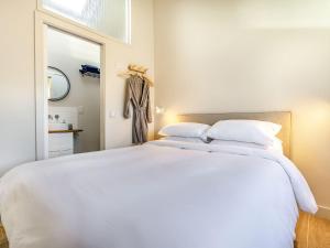 a bedroom with a large white bed and a mirror at Little Glencrest in Copley