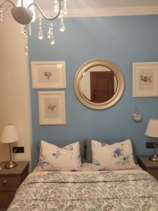 マラガにあるApartamento "Casa del Árbol"の青い壁のベッドルーム1室、鏡付きのベッド1台が備わります。