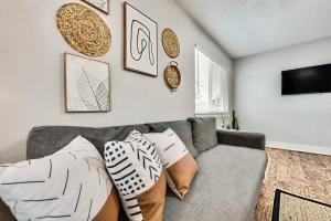 a living room with a gray couch with pillows at Lovely Dallas Flat Near Downtown in Dallas