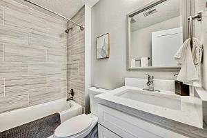 a bathroom with a sink and a toilet and a mirror at Lovely Dallas Flat Near Downtown in Dallas