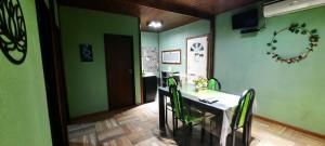 a dining room with green walls and a table and chairs at Brisas de Killa in General Rodríguez