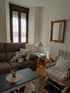 a living room with a couch and a chair at Alojamiento turístico Carvi in Arévalo