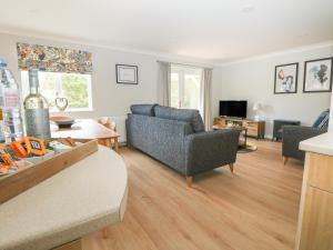 a living room with a couch and a table at Heather's Cottage in Budock Water