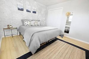 a bedroom with a bed and a brick wall at The City Escape & Arboretum Tickets Included in Dallas