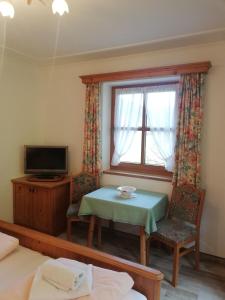 Habitación con mesa, ventana y TV. en Schiederhof, en Mittersill