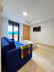 a blue couch in a living room with a tv at Fabuloso apartamento completo centro ciudad in Móstoles