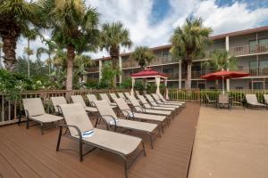 a row of chairs and umbrellas on a deck at Red Roof Inn PLUS+ & Suites Naples Downtown-5th Ave S in Naples