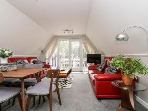 sala de estar con sofá rojo y mesa en Devine Lodge, en Callington