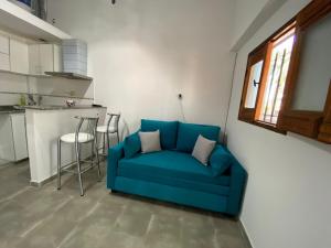 a blue couch in a room with a kitchen at Minicasa moderna in Castelar