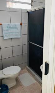 a bathroom with a toilet and a shower stall at Pousada Popular Casa de Madeira in Porto De Galinhas