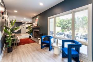 a living room with blue chairs and a fireplace at Kasa Edison House South End Dilworth Charlotte in Charlotte