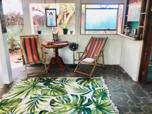 a room with two chairs and a table and a rug at Rainbow Caravan Hostel in Las Pilas