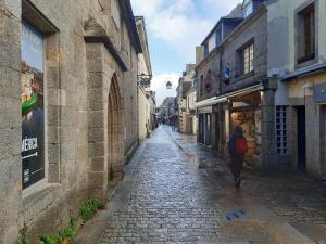a woman walking down a street in an alley at Urban Sunny & Cosy in Concarneau