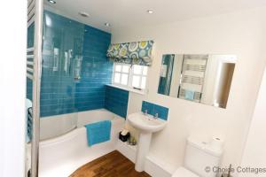 a bathroom with a sink and a tub and a toilet and a sink at CROYDE WHITE HOUSE 4 Bedrooms in Croyde +37 photos